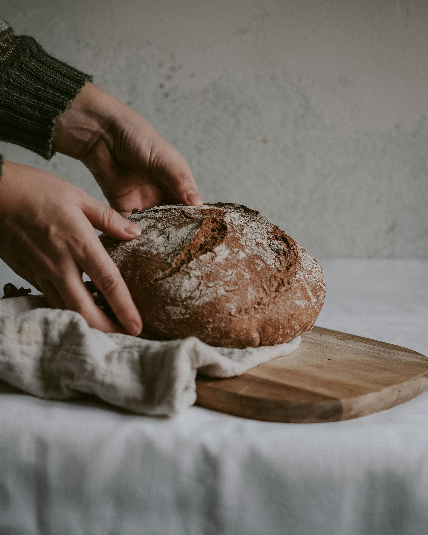 Hands shaping a sourdough loaf